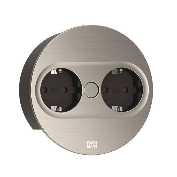 Prise double en métal de forme ronde, adaptée aux espaces intérieurs modernes, avec un interrupteur central au-dessus des emplacements de branchement.