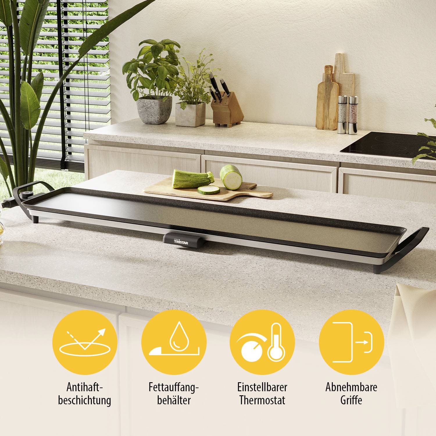 Une plaque de grill électrique sur un plan de travail de cuisine avec des poignées amovibles, un thermostat réglable et un revêtement anti-adhésif. Des plantes et des ustensiles de cuisine sont visibles en arrière-plan.