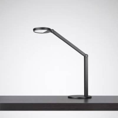 Une lampe de table moderne en noir avec un bras articulé est posée sur une table sombre.