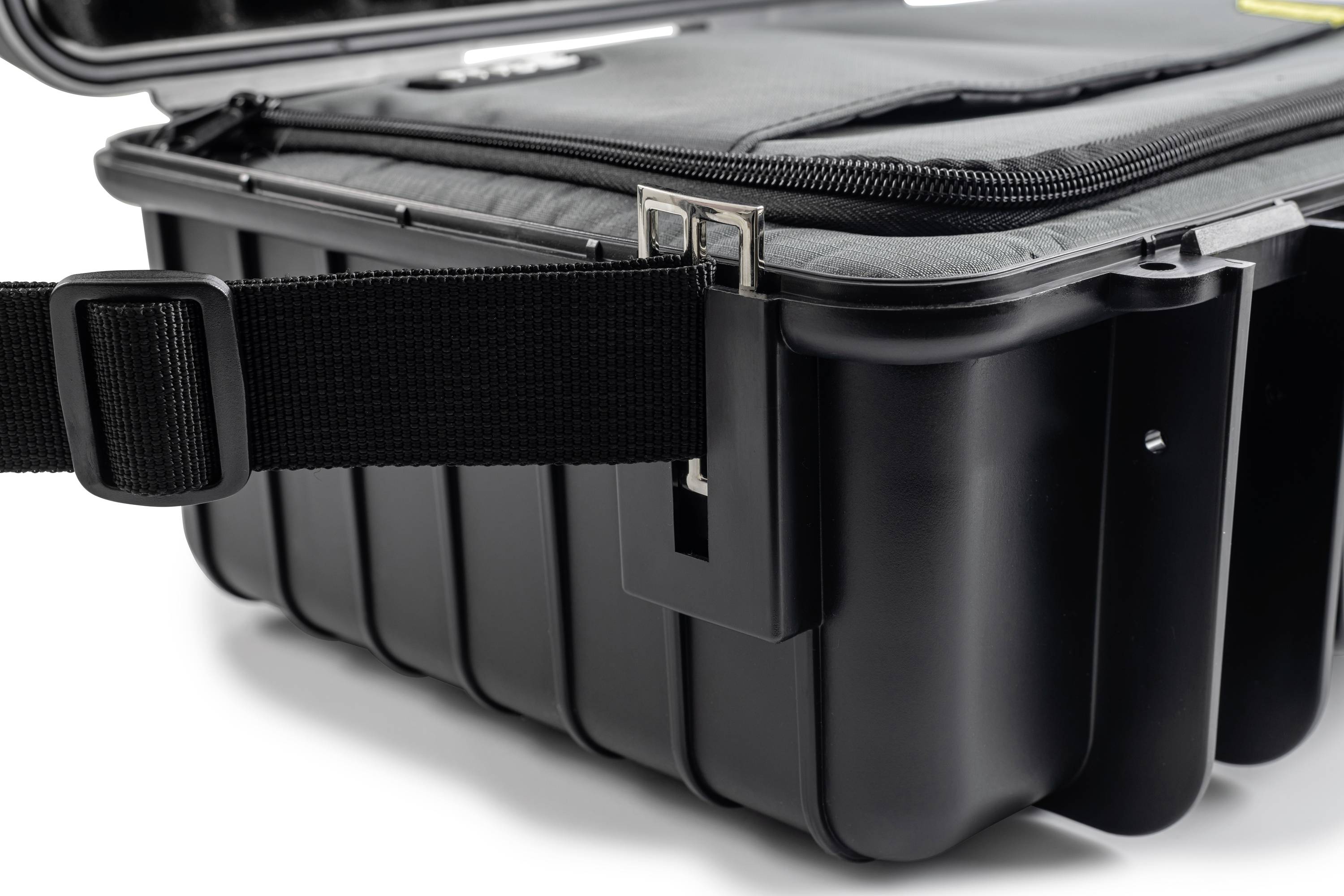 Valise rigide noire avec une sangle robuste et une fermeture éclair, ouverte et partiellement visible.