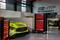Une voiture de course jaune avec le logo 'Mann Filter' dans un atelier, avec des armoires à outils et le logo HTP Motorsport sur le mur.
