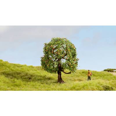 Une petite figurine se tient sur une prairie verte, à côté d'un arbre portant des fruits colorés, sous un ciel bleu.