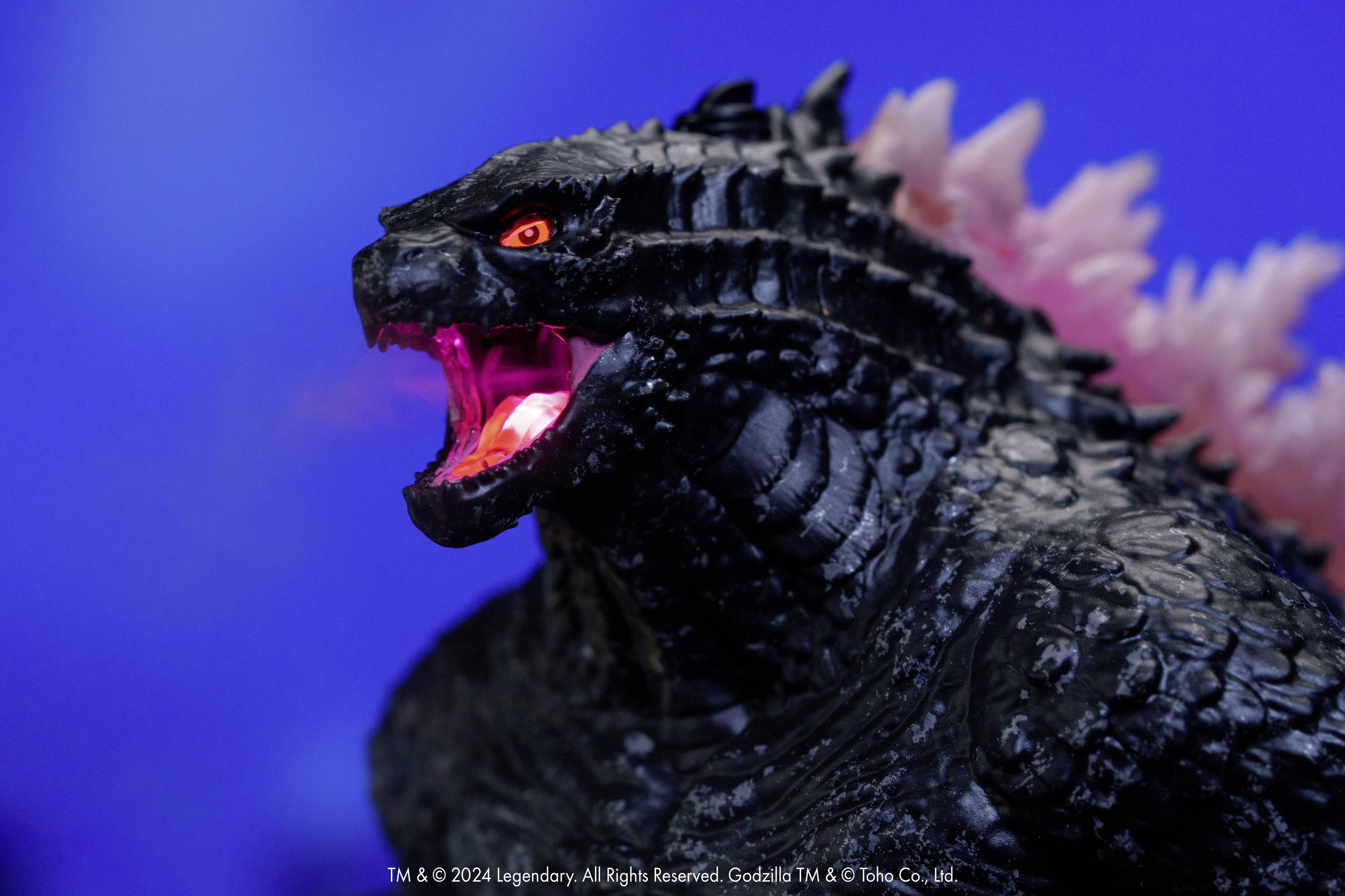 Un dinosaure noir aux yeux lumineux et aux piquants roses pousse un rugissement devant un fond bleu.