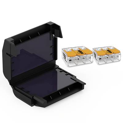 Boîte de connexion électrique en matériau noir, représentée ouverte, à côté de deux bornes de connexion transparentes orangées.