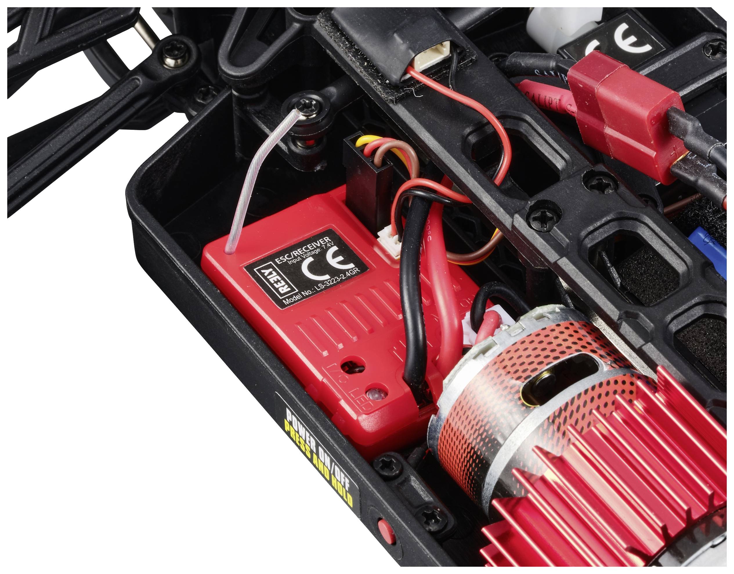 Vue intérieure d'une maquette de voiture montrant le moteur, le câblage et un composant électronique rouge portant le marquage CE.