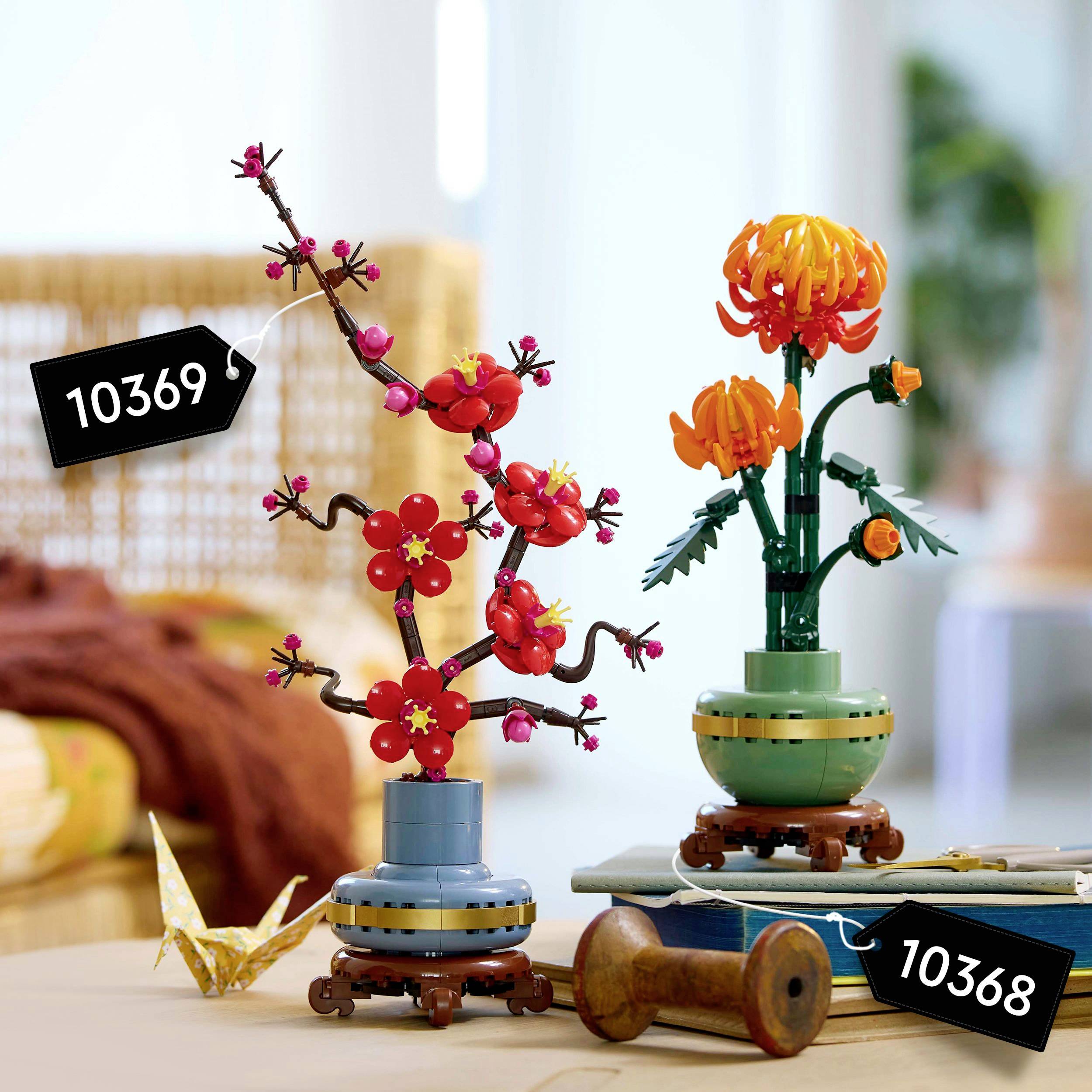 Ensembles LEGO avec des motifs floraux. À gauche : Arbre à fleurs roses (10369). À droite : Fleur orange dans un vase (10368). Salon en arrière-plan.