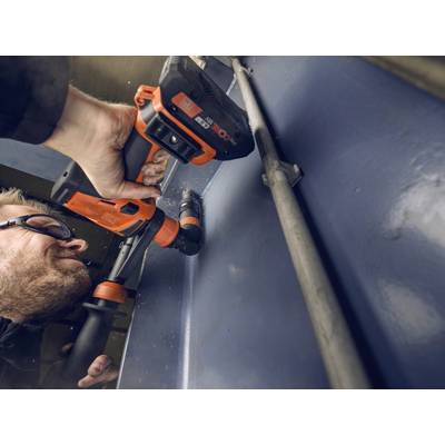 Un homme porte des lunettes de protection et utilise une perceuse orange et noire pour percer une surface métallique.
