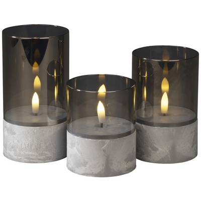 Trois bougies décoratives avec abat-jour gris et socle en béton. Les flammes brûlent calmement et uniformément, créant une atmosphère chaleureuse.