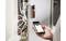 Une personne utilise un smartphone pour récupérer des données à partir d'un appareil de mesure fixé à un câble de machine.