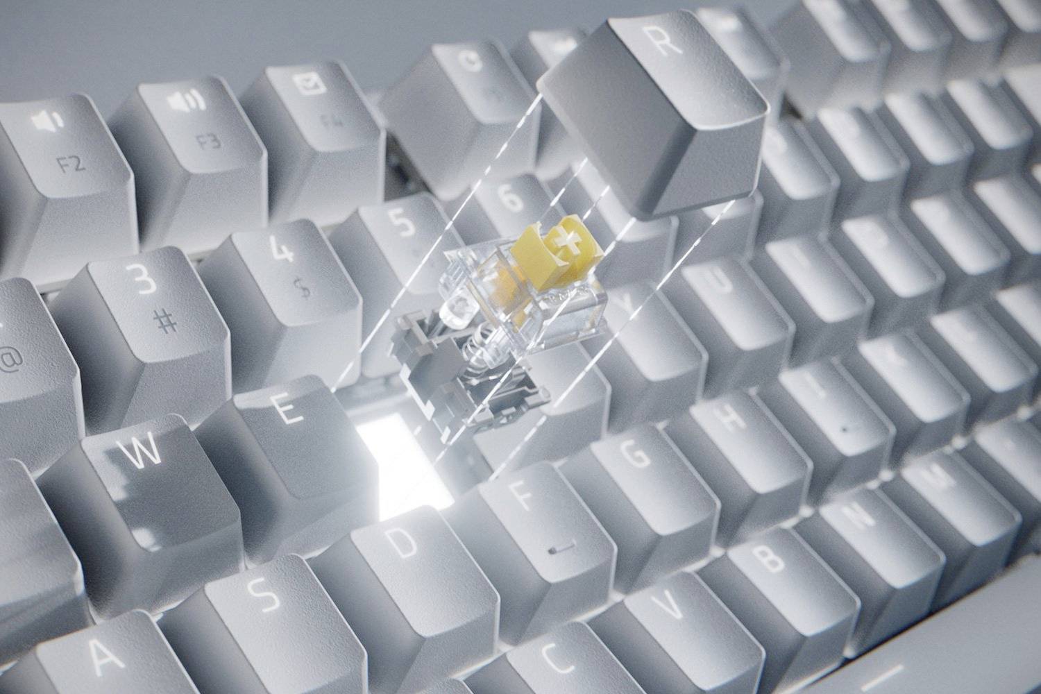 Gros plan d'un clavier d'ordinateur avec une touche retirée, révélant un interrupteur jaune et un boîtier transparent. Touches rétroéclairées.