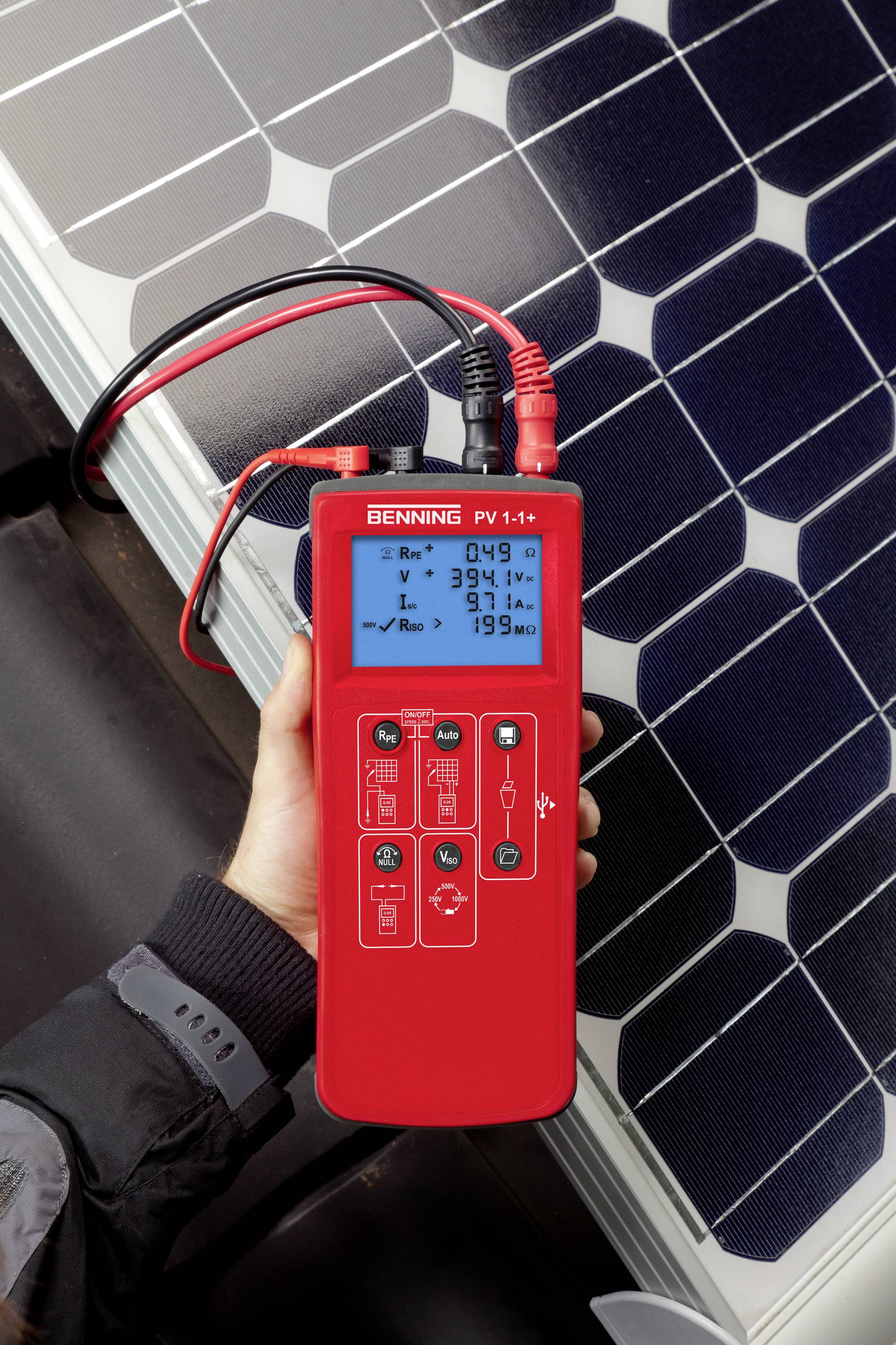 Une personne tient un appareil de mesure numérique rouge à côté d'un panneau solaire. L'appareil affiche des valeurs de mesure concernant l'efficacité énergétique solaire.