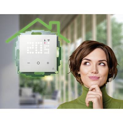 Une femme regarde un écran domotique affichant '20° C', avec un symbole de maison en vert au-dessus, dans une pièce moderne.