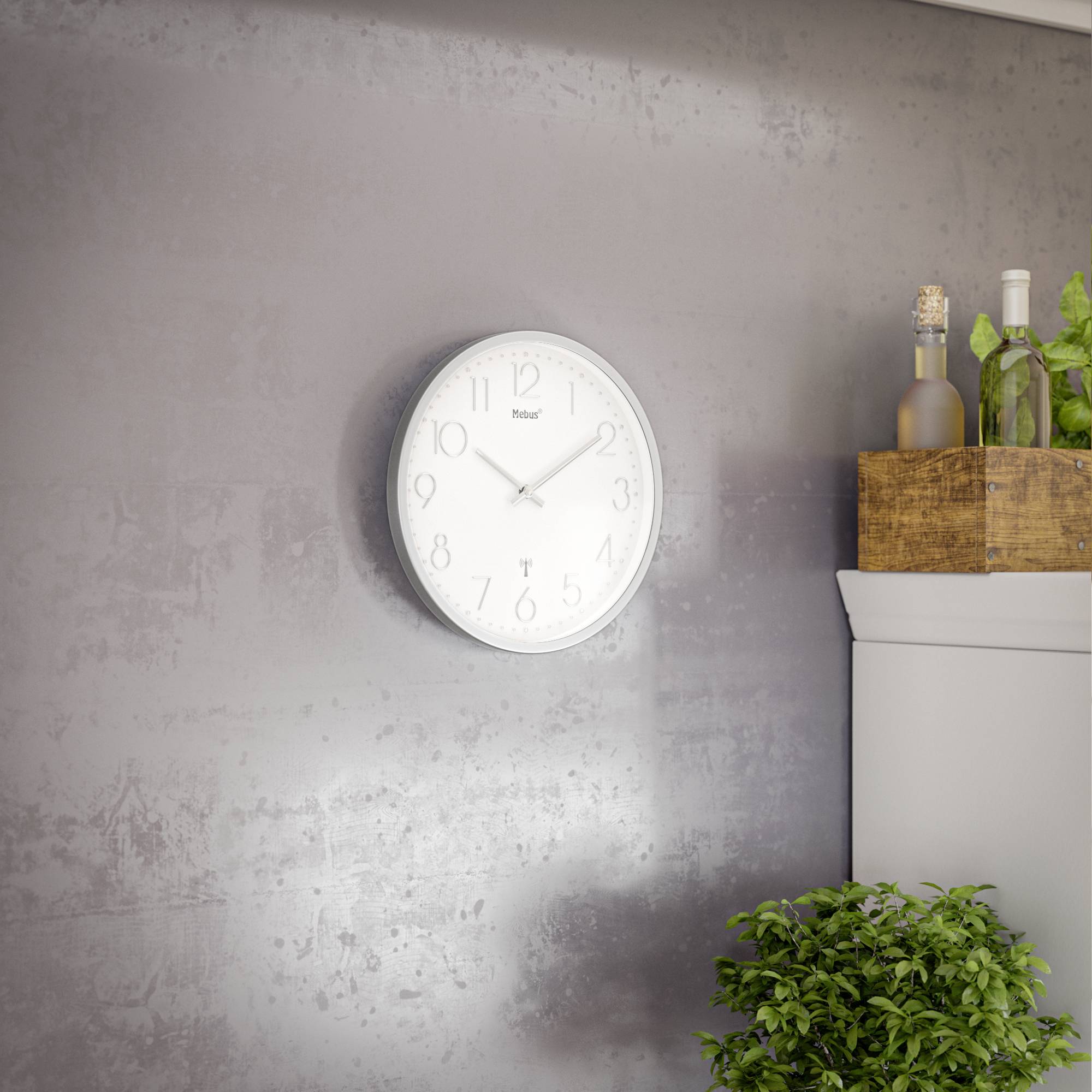 Une horloge murale indique environ 10h11. À côté se trouve un coffret en bois contenant des bouteilles et des plantes, posé sur une armoire.