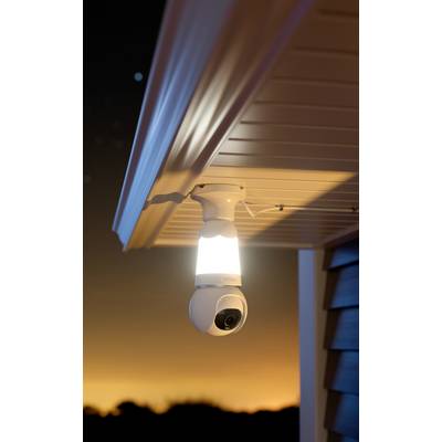Caméra de surveillance installée sous un avant-toit au coucher du soleil, prête à surveiller un espace extérieur.