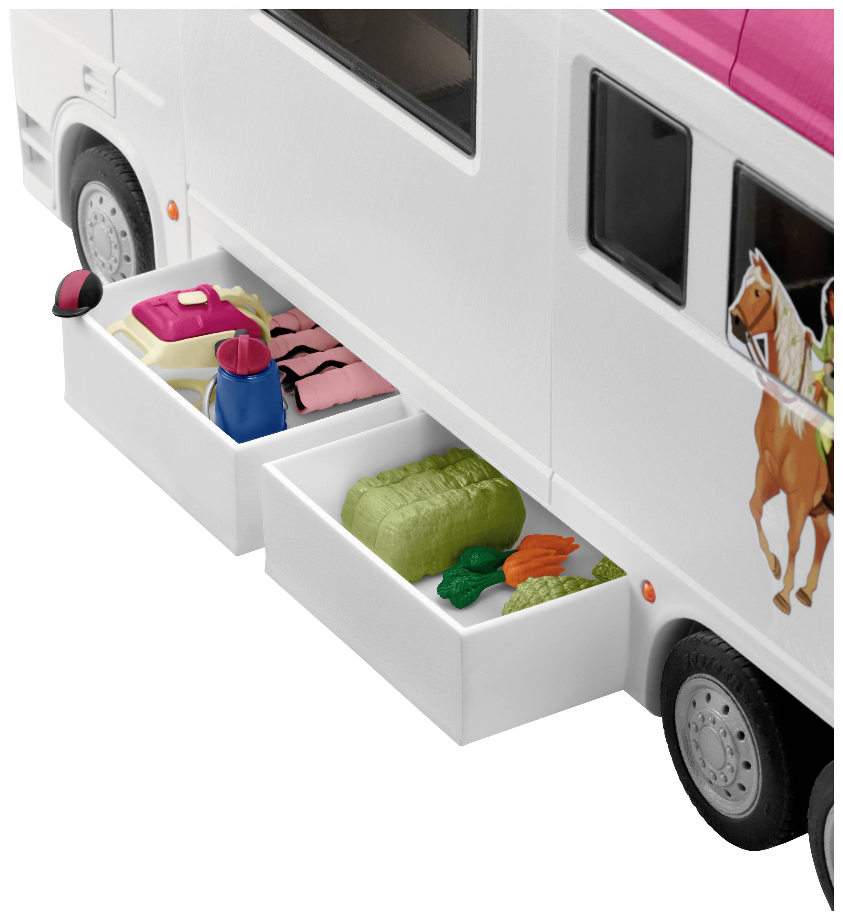 Un camping-car miniature avec des tiroirs ouverts contenant de petits vêtements et des aliments. À l'extérieur, des chevaux sont représentés.