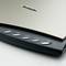 Un scanner plat avec cinq touches : « Copier », « OCR », « E-mail », « Personnalisé », « PDF ». Nom de la marque visible en haut du scanner.