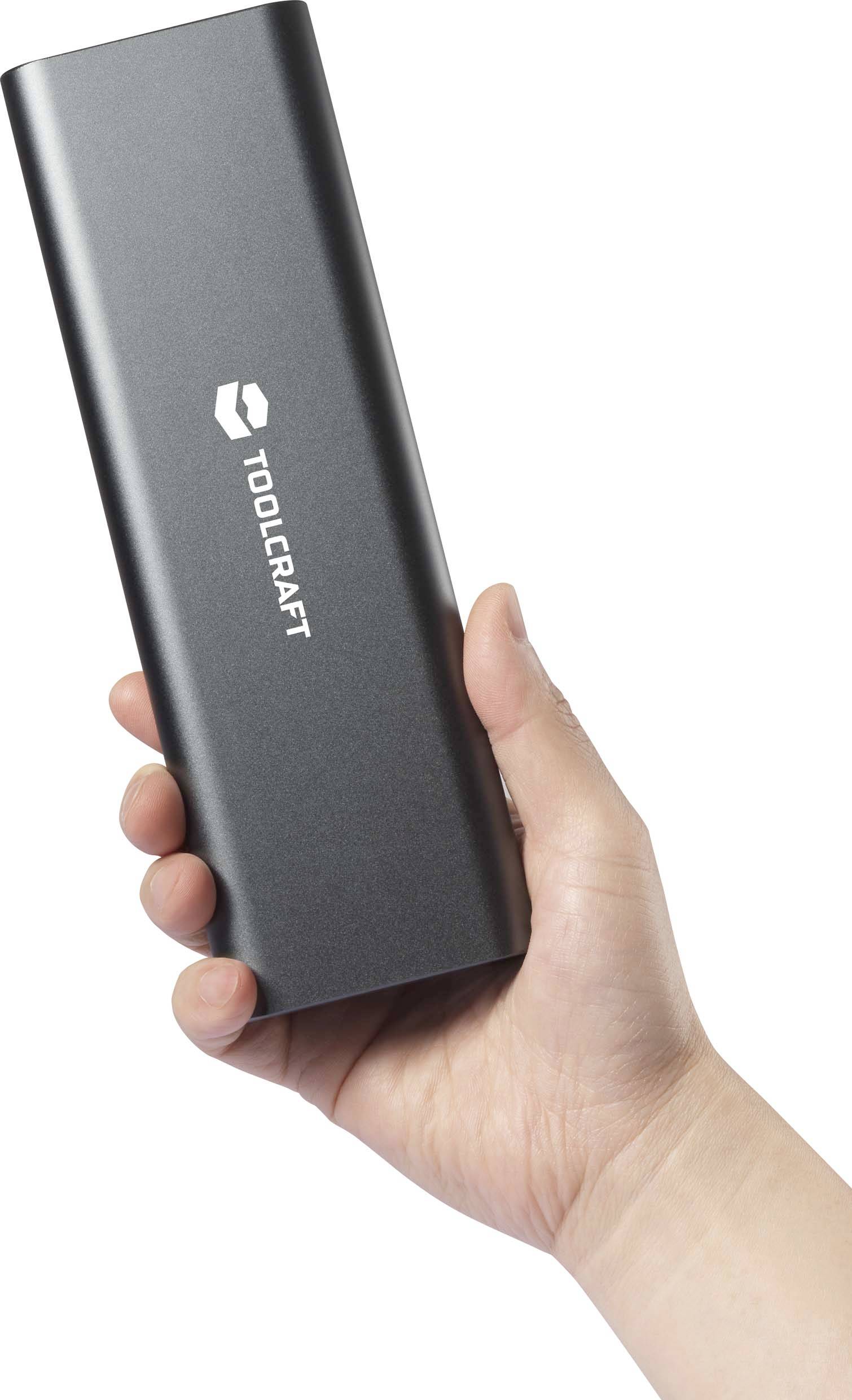 Une main tient un appareil rectangulaire noir de la marque Toolcraft.