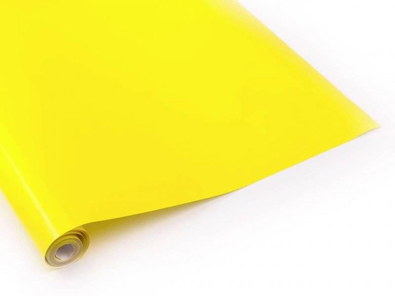 Un rouleau brillant de papier jaune est étalé sur un fond blanc.