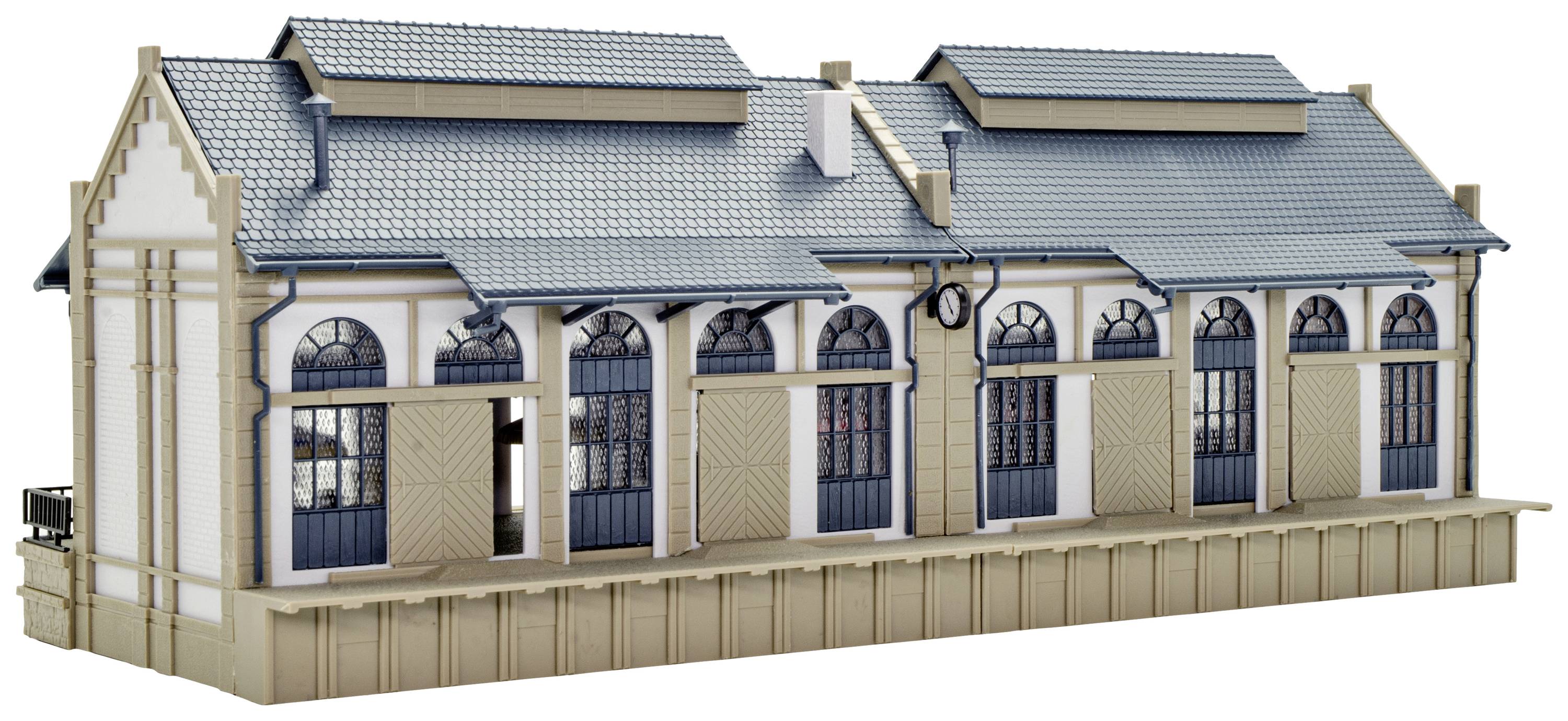 Un modèle d'un bâtiment de gare historique avec des toits bleus et de grandes façades vitrées, révèle des détails architecturaux.