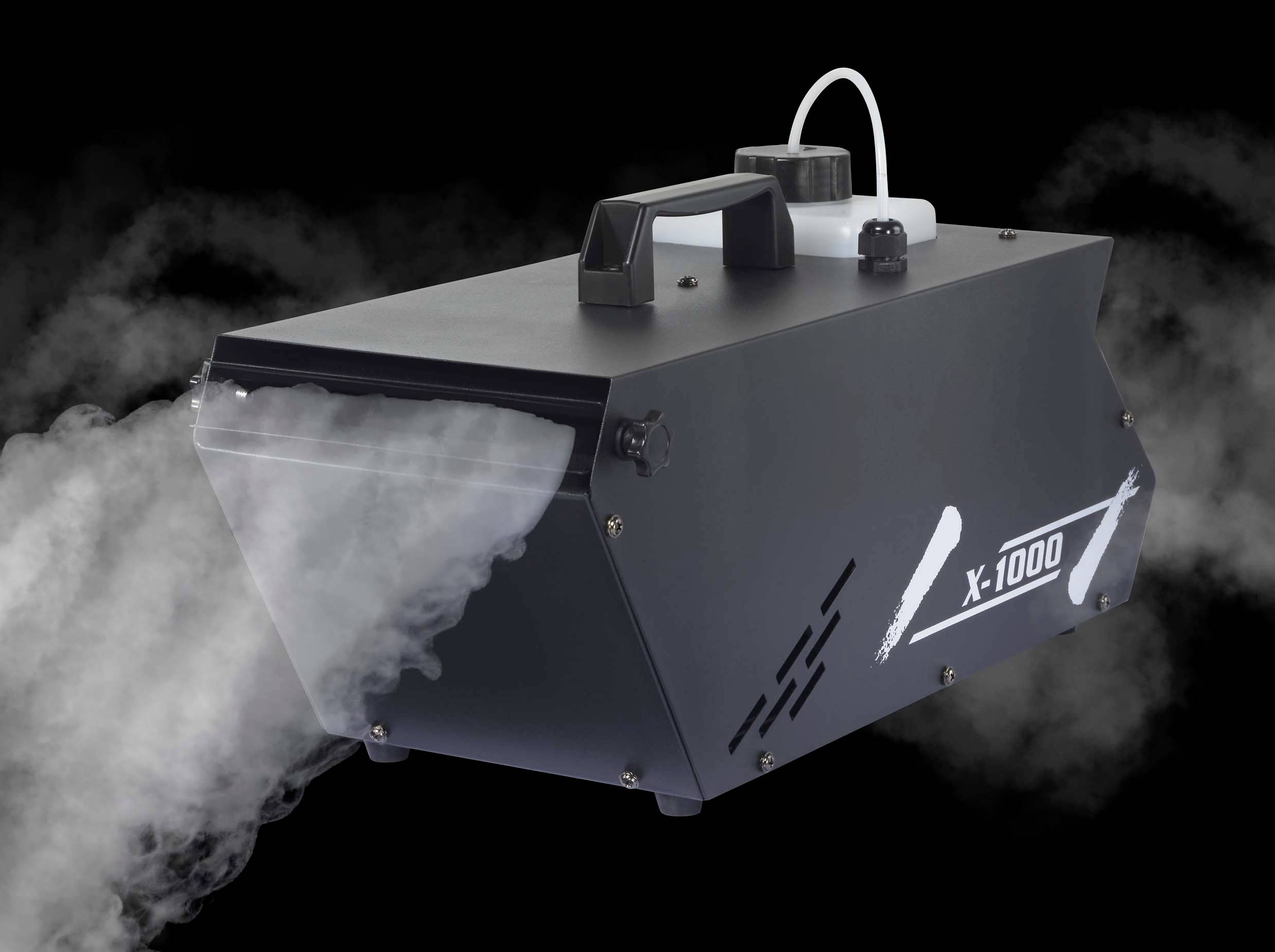 'La machine à brouillard X-1000 émet de la fumée blanche. Boîtier noir avec poignée et réservoir connecté. Arrière-plan de studio noir.'
