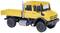 Modèle jaune d'un camion tout-terrain avec plateau ouvert, pneus robustes et échappement argenté sur fond blanc.