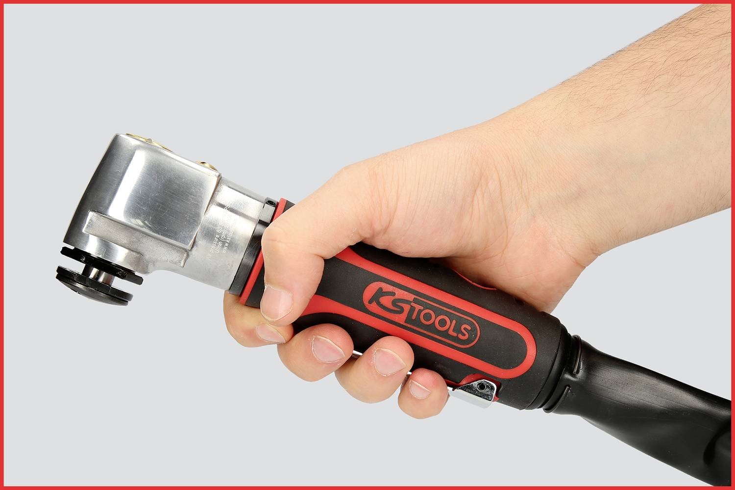 Une main tient un outil portant l'inscription 'KS Tools', reconnaissable à sa poignée rembourrée et sa tête métallique.