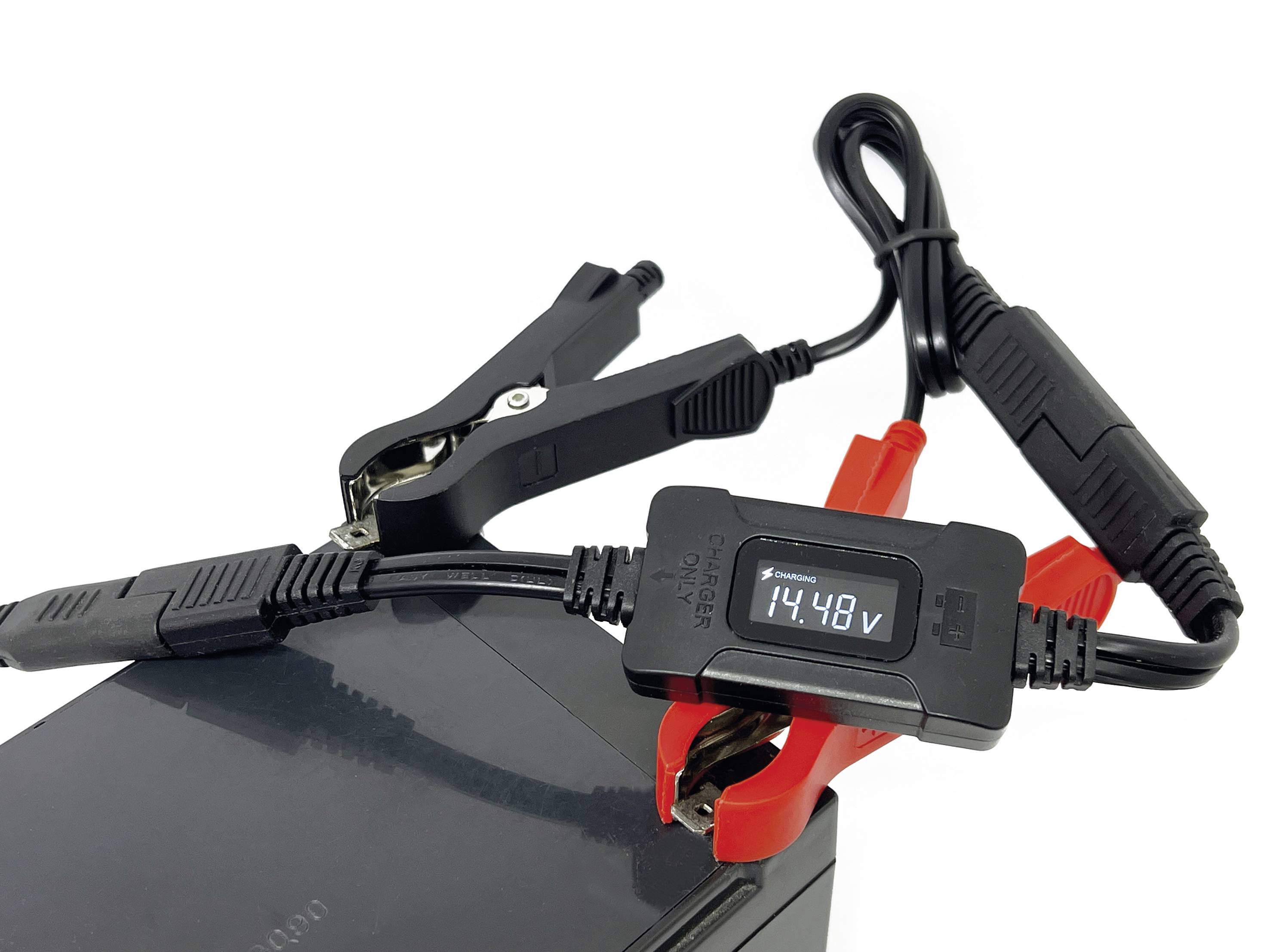 Chargeur de batterie avec affichage numérique, indiquant 14,48 V. Connecté à une batterie noire à l'aide de pinces rouge et noire.