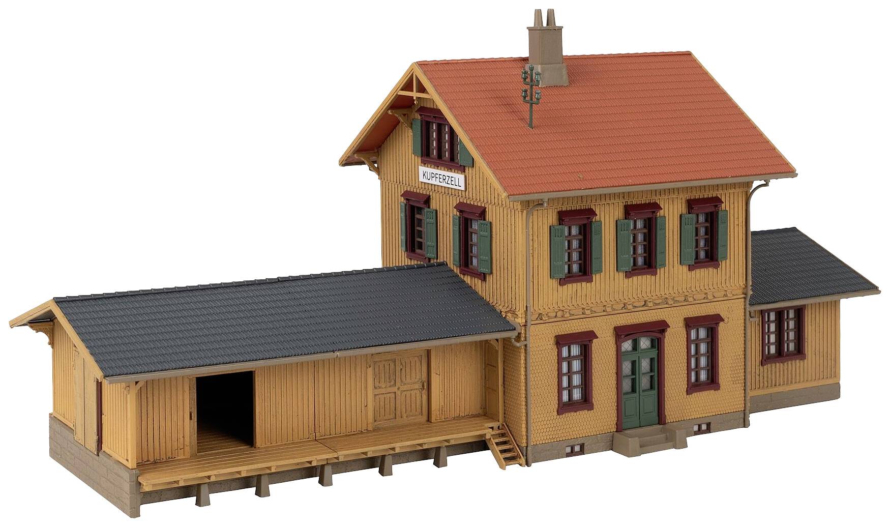 Maquette d'un bâtiment de gare à deux étages de style traditionnel avec un toit rouge et un revêtement en bois. Panneau : « Koppigen ».
