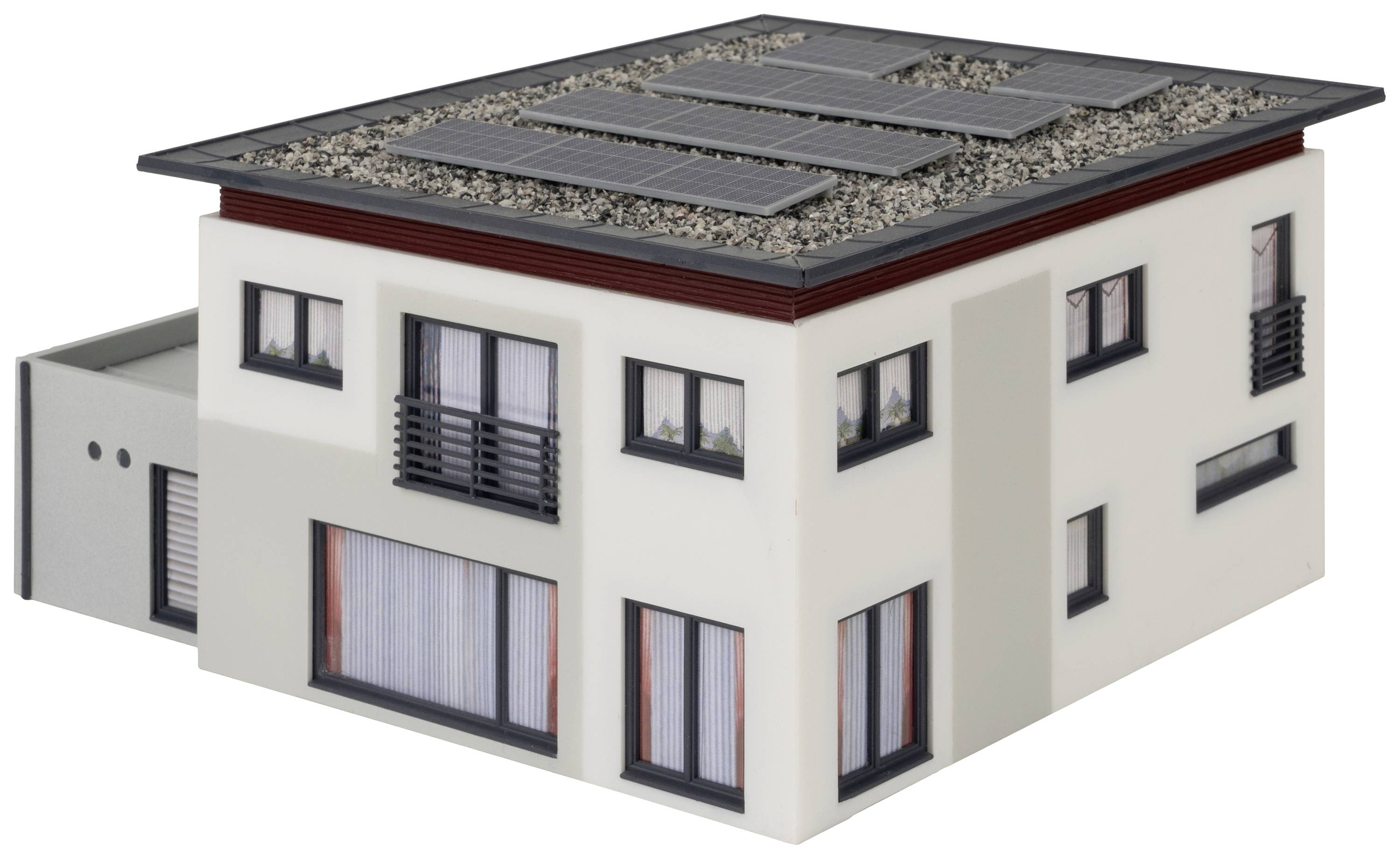 Bâtiment moderne de deux étages avec un toit plat, équipé de panneaux solaires. Grandes fenêtres, peinture blanche, garage sur le côté gauche.