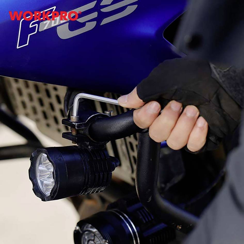 Une personne installe un éclairage sur un guidon de vélo à l'aide d'une clé Allen. En haut à gauche est inscrit le mot 'WORKPRO'.