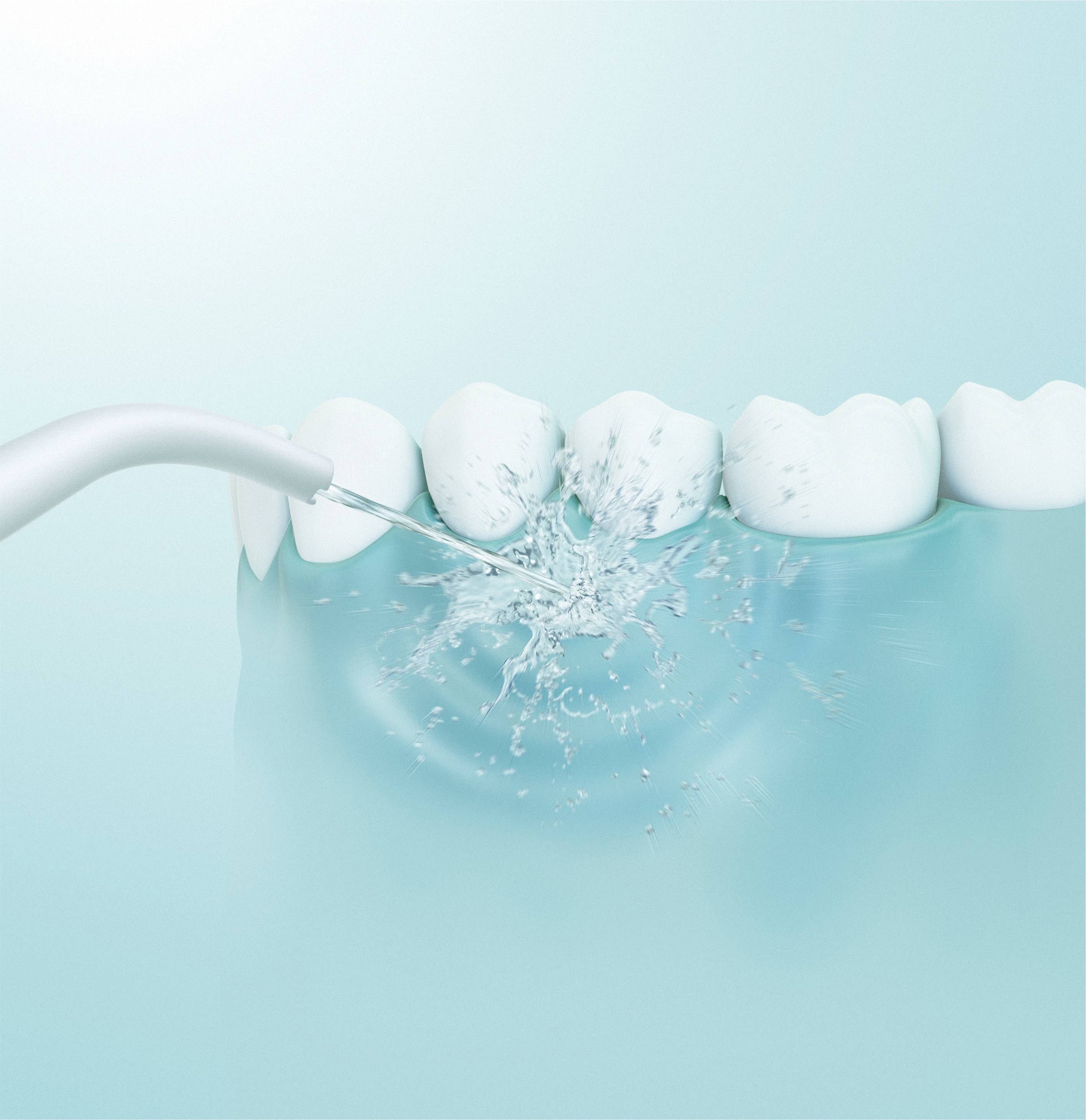 'Gros plan d'un jet d'eau dentaire projetant un jet d'eau pour nettoyer entre les dents, représenté sur un fond clair de couleur aqua.'