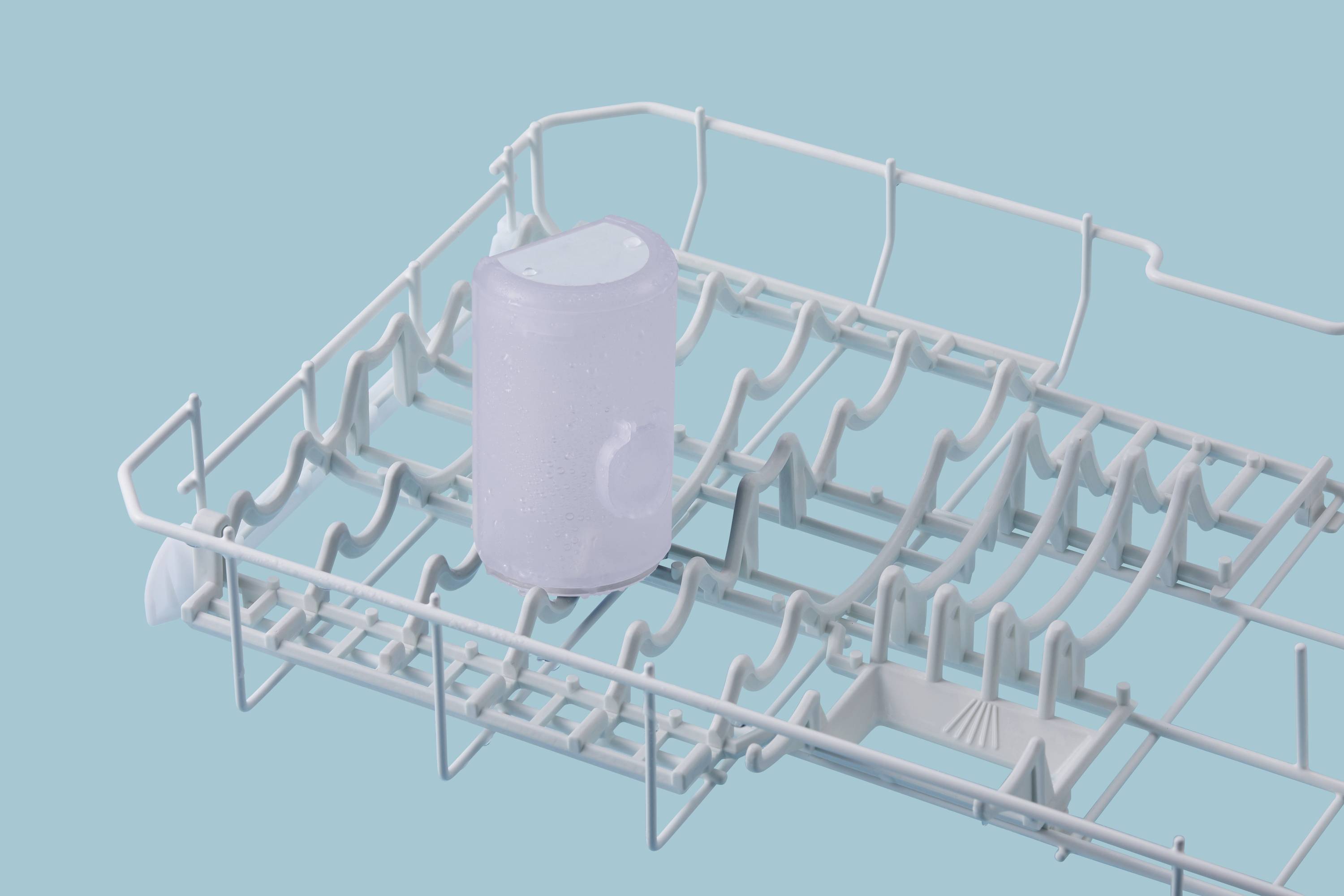 Un panier de lave-vaisselle vide, avec un récipient transparent au centre, sur un fond bleu.