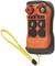 Une télécommande radio portable orange avec des touches noires et un bouton de démarrage vert, fixée à une dragonne jaune.