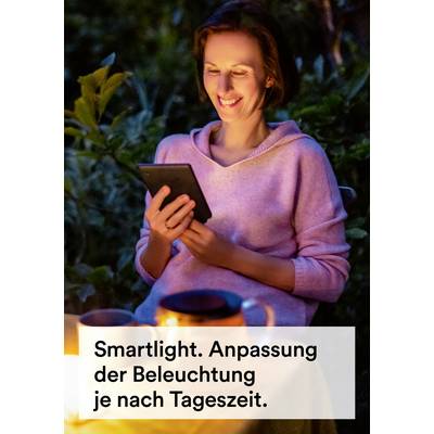 Une personne est assise dehors à la lumière des bougies et lit sur une tablette. Texte : 'Smartlight. Adaptation de l'éclairage selon l'heure de la journée.'
