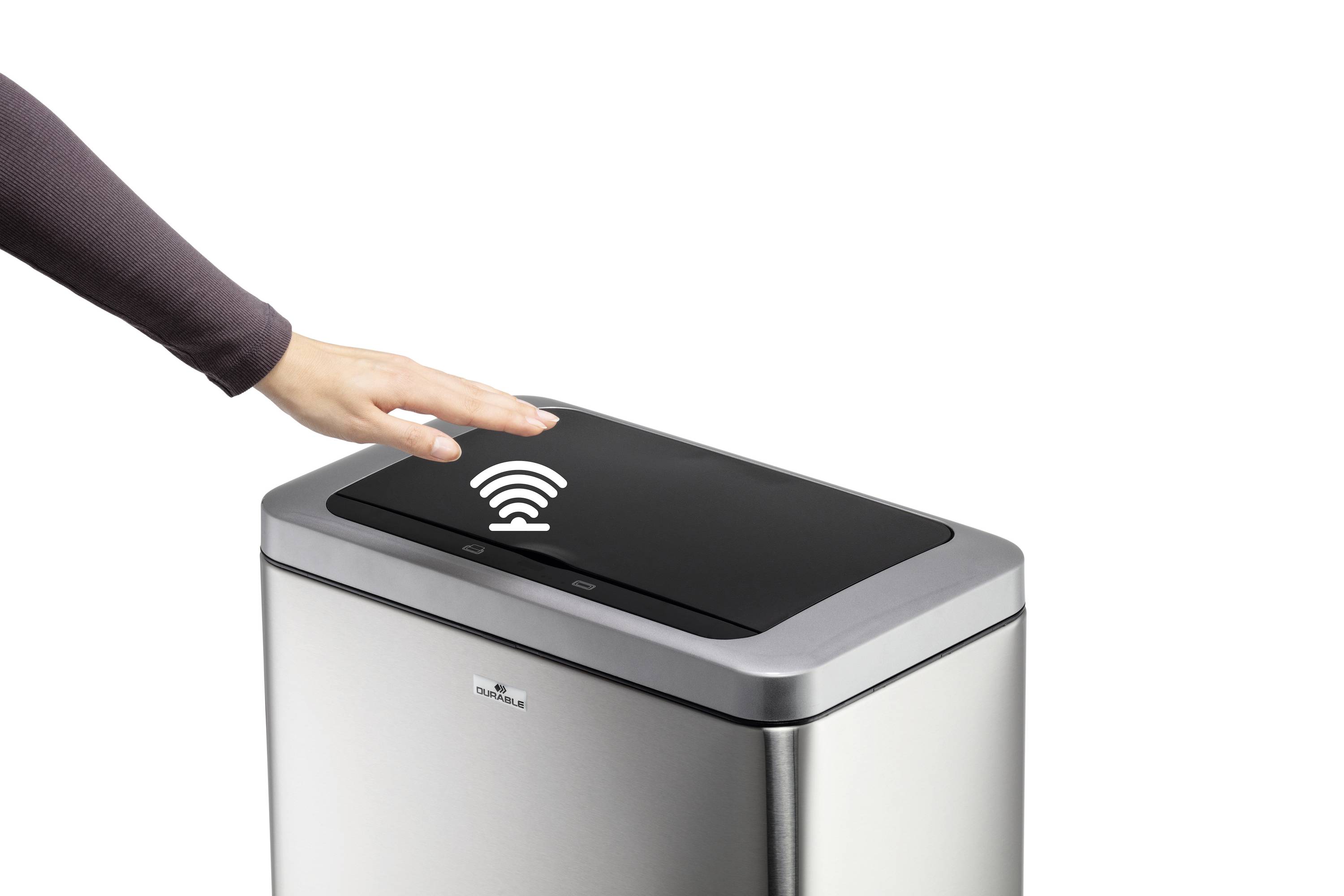 Une main ouvre sans contact une poubelle avec un capteur. La poubelle est argentée et possède un élément de commande noir avec un symbole Wi-Fi.