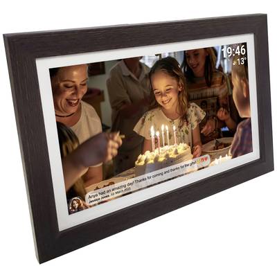 Une jeune fille souriante se tient devant un gâteau d'anniversaire garni de bougies. Des adultes et d'autres enfants l'entourent dans une pièce décorée pour la fête.