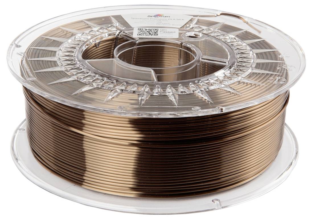 Une bobine transparente contenant du filament d'impression 3D couleur cuivre, posée sur une table.