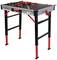 Table de travail pliable avec plateau noir et pieds rouges. Hauteur réglable, adaptée à divers travaux manuels.