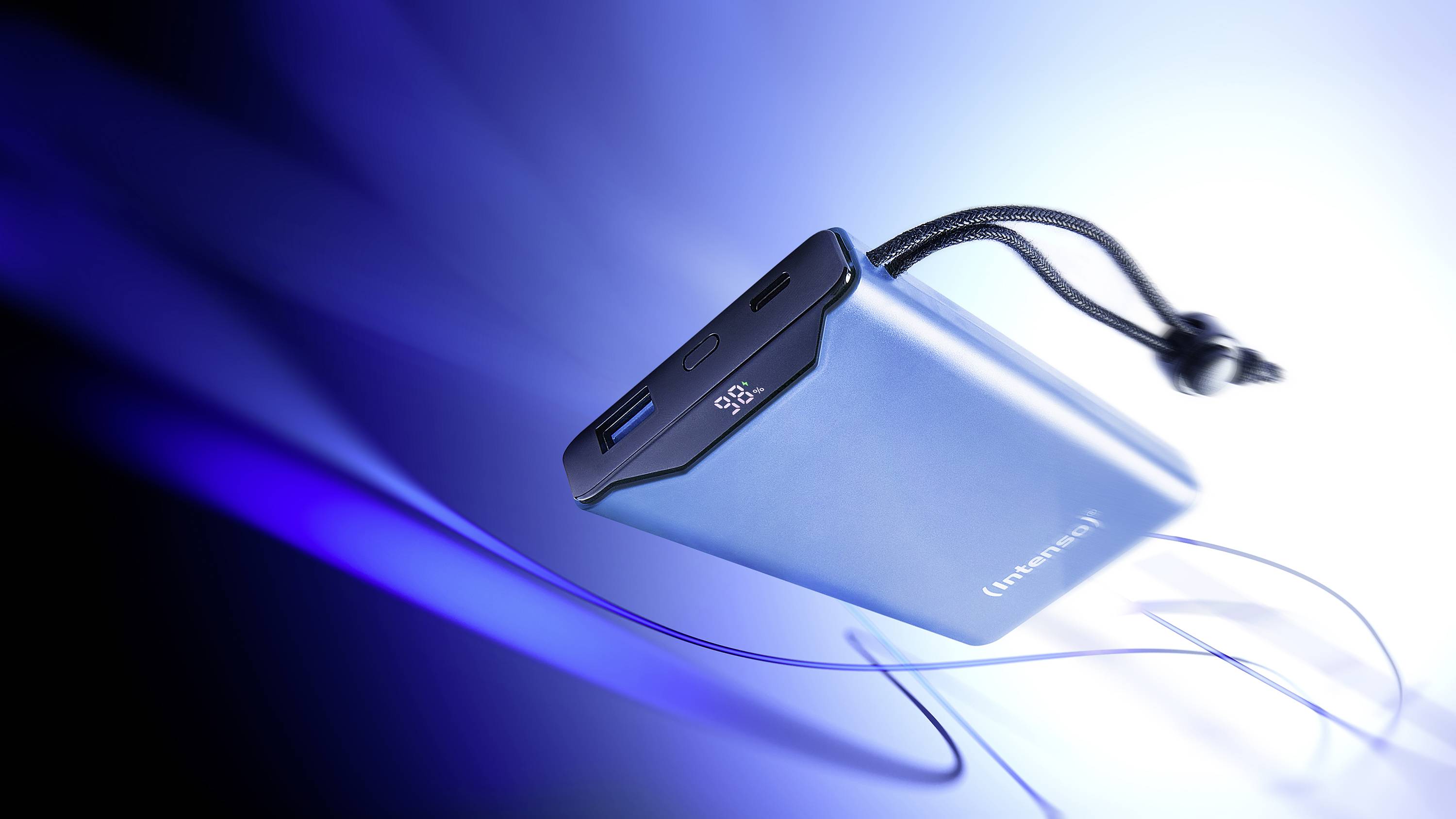 Un chargeur portable bleu avec un affichage LED indique '98%' de charge, sur un fond avec des rayures lumineuses bleues.