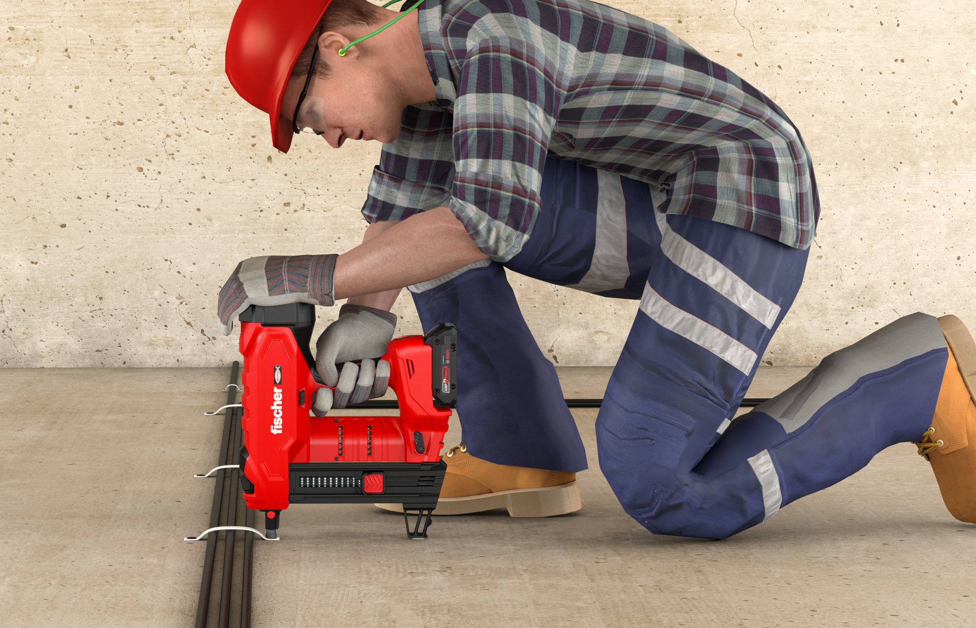 Ouvrier de la construction agenouillé utilisant un pistolet à clous rouge pour fixer des câbles au sol à côté d'un mur.