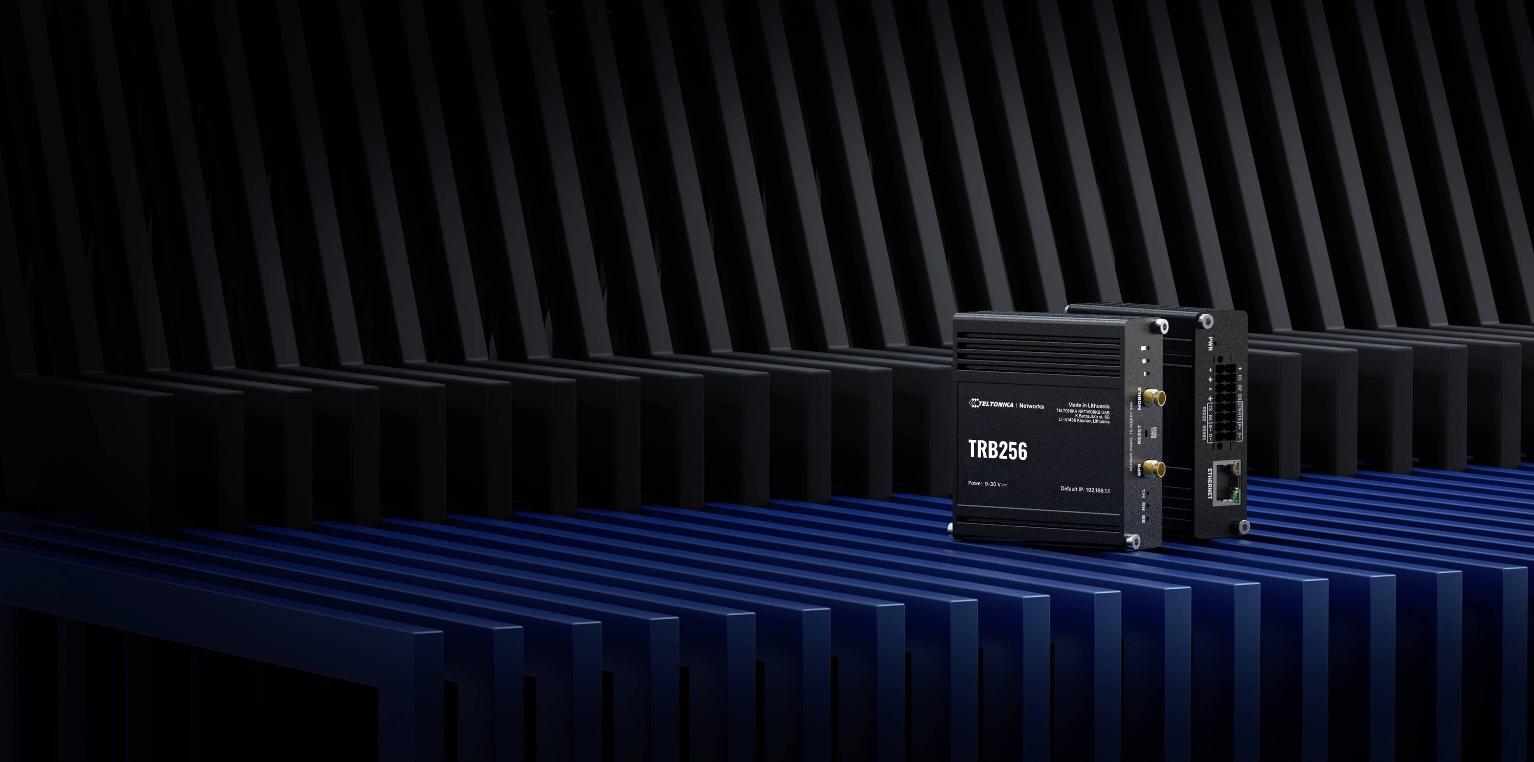 Un dispositif de passerelle industrielle portant l'inscription 'TRB256' sur une surface striée, devant un arrière-plan strié bleu foncé.