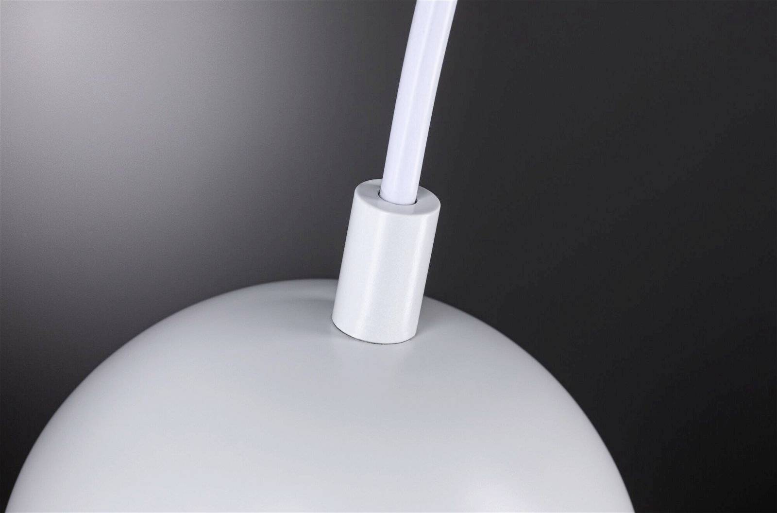 Lampe blanche, sphérique et en métal, partiellement visible du dessus, sur un fond sombre.