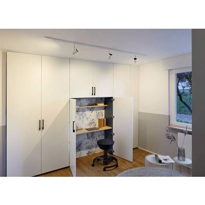 Un espace de travail intégré dans un mur d'armoire blanc avec un sol en bois clair. Un tabouret noir est placé devant des portes ouvertes.