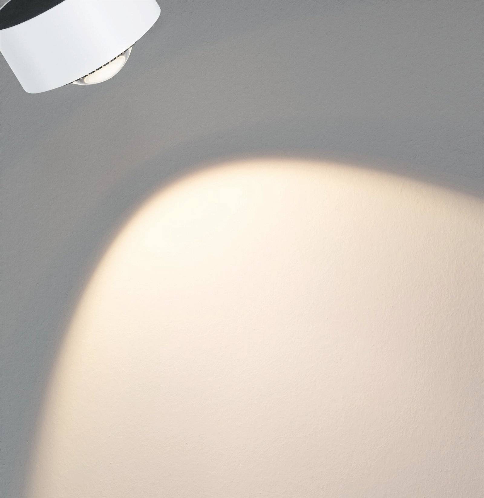 Un projecteur projette un faisceau lumineux circulaire sur un mur, créant ainsi une zone lumineuse.