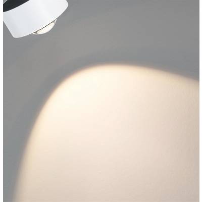 Un projecteur projette un faisceau lumineux circulaire sur un mur, créant ainsi une zone lumineuse.
