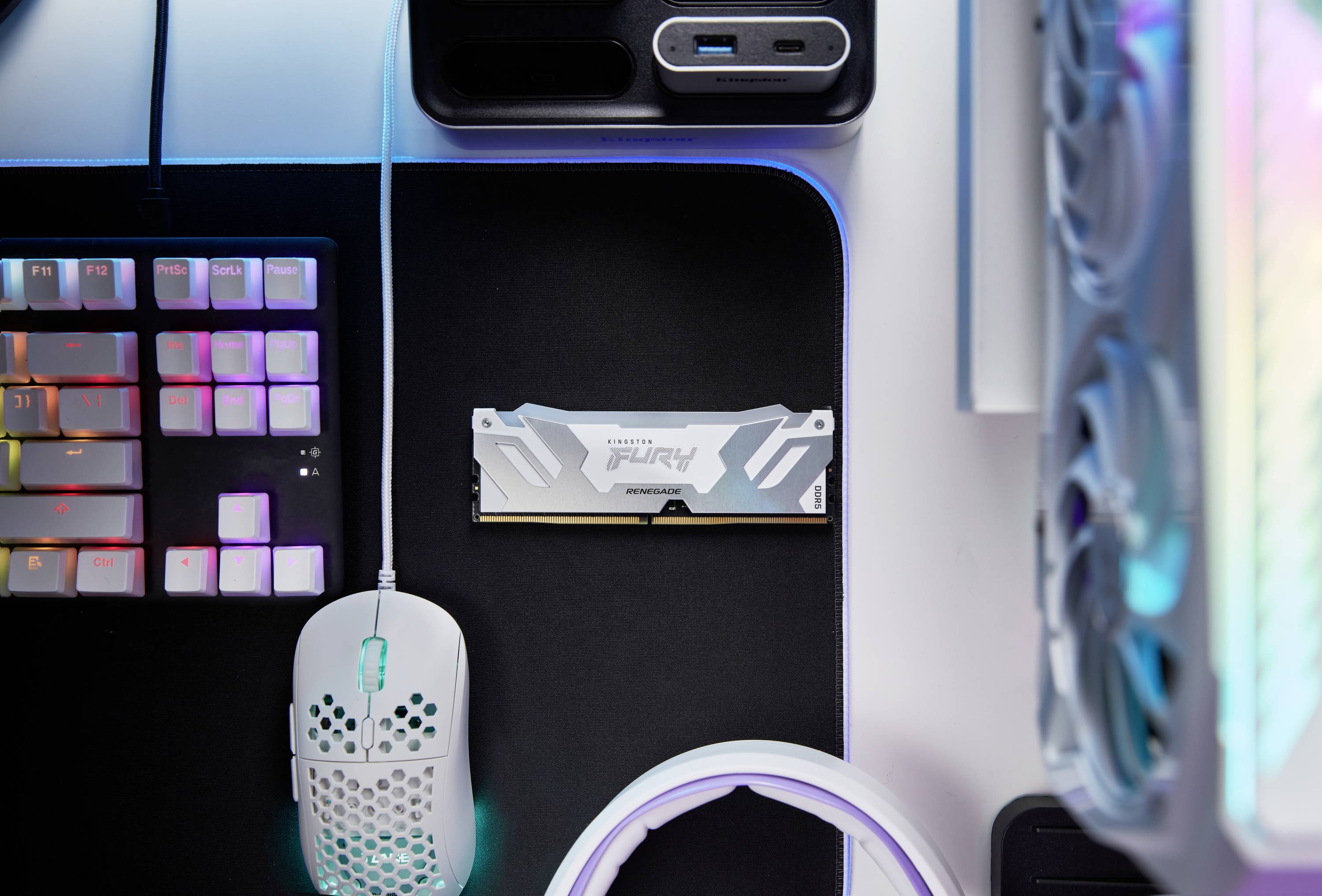 Un bureau avec un clavier, une souris et un module RAM. Ce setup est adapté aux travaux informatiques ou au gaming.