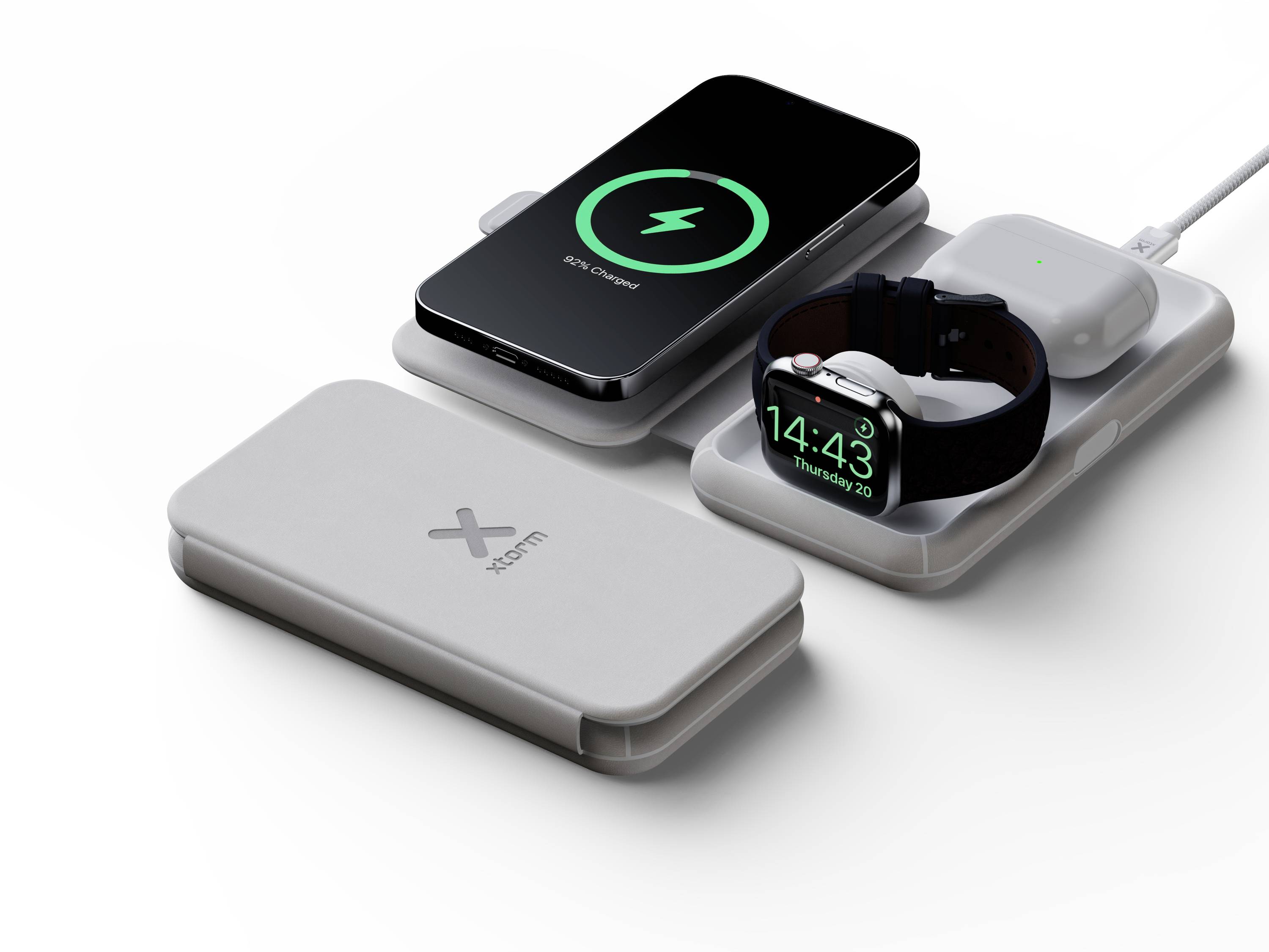 Chargeur sans fil à deux zones de charge : smartphone affichant '90% chargé', à côté une montre-bracelet et des écouteurs en cours de charge.