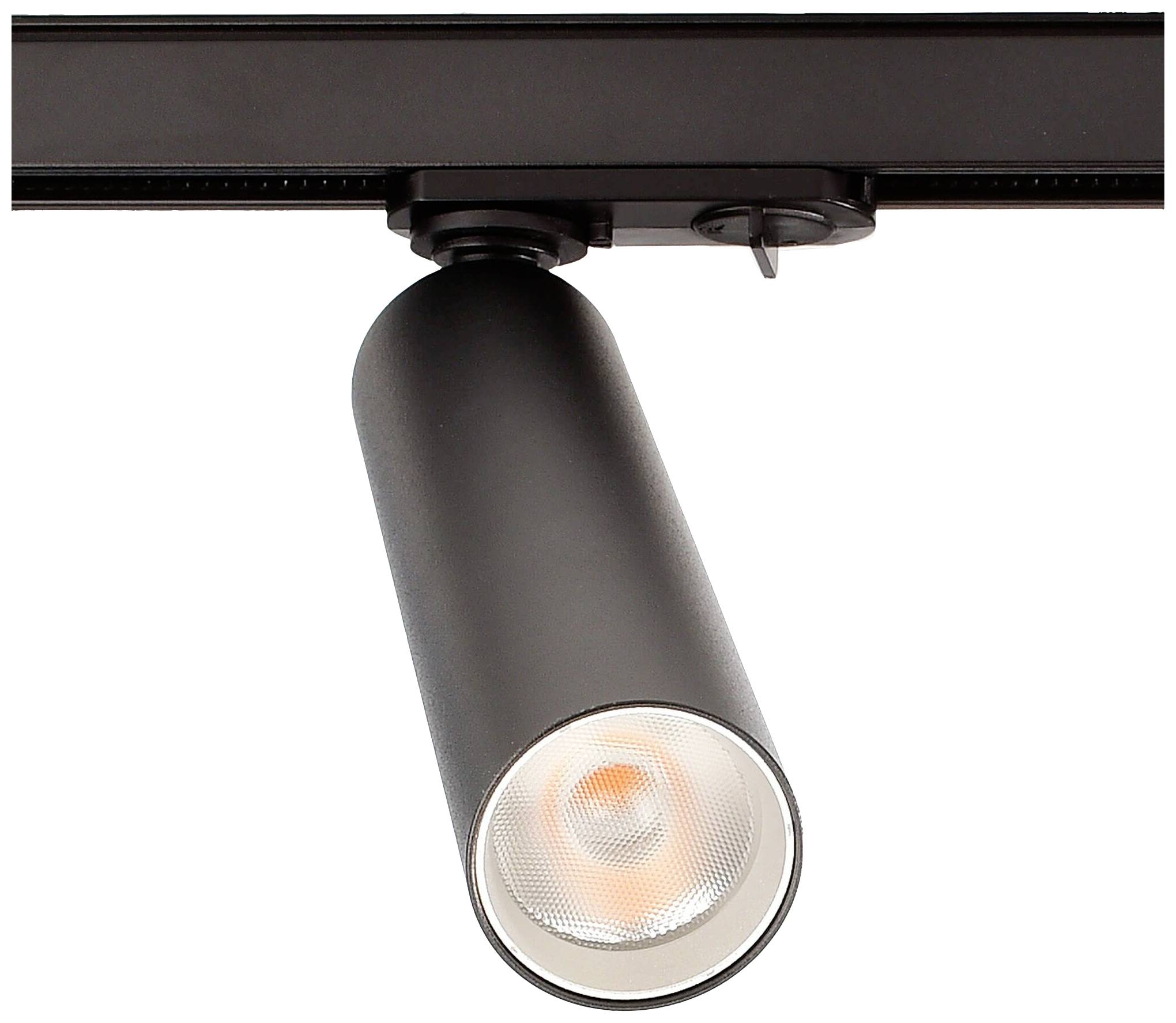 Un projecteur cylindrique noir est monté sur un rail. Le projecteur est allumé et brille intensément.