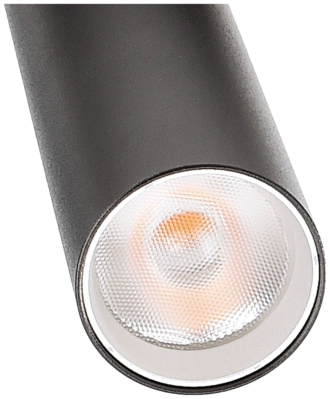Lampe noire cylindrique avec un réflecteur lumineux, montrant une source de lumière chaleureuse.