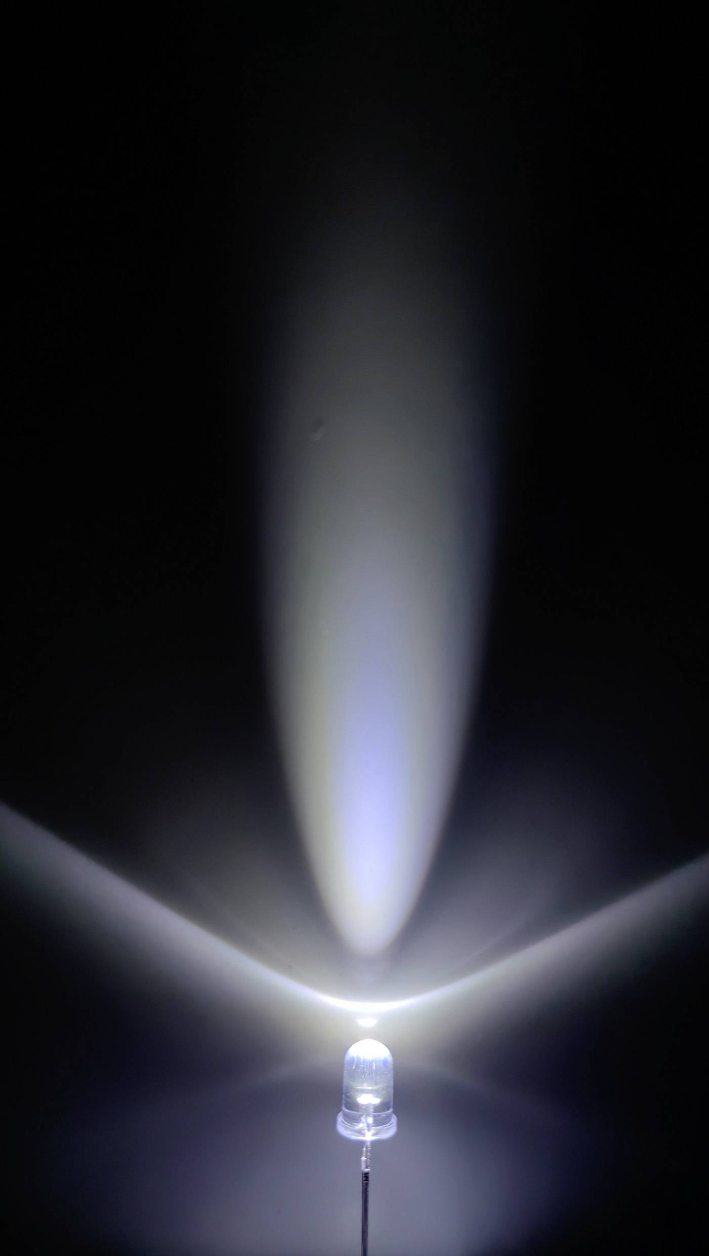 Une seule lampe LED brille dans une pièce sombre, projetant sa lumière en forme de cône vers le haut et créant une légère lueur bleutée.